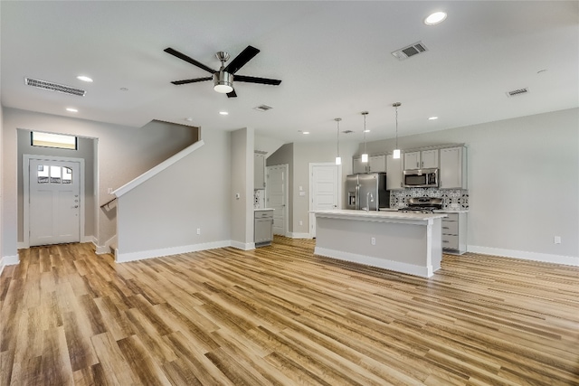 unfurnished living room with ceiling fan, light wood-type flooring, and sink