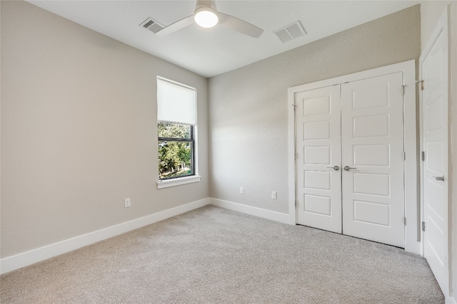 unfurnished bedroom with ceiling fan, a closet, and light carpet