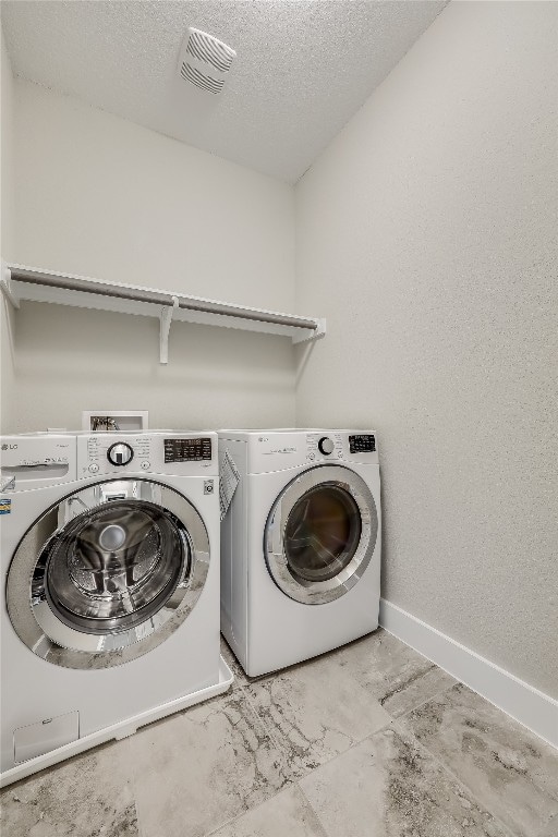 washroom featuring independent washer and dryer and a textured ceiling