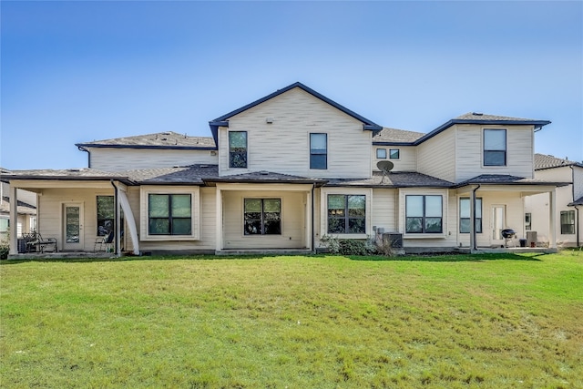 back of house with a patio and a lawn