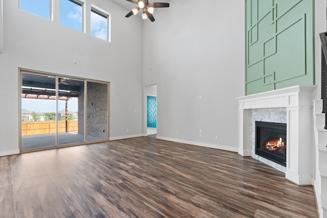 unfurnished living room featuring dark wood-type flooring and ceiling fan