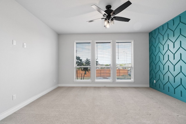 spare room featuring light carpet and ceiling fan