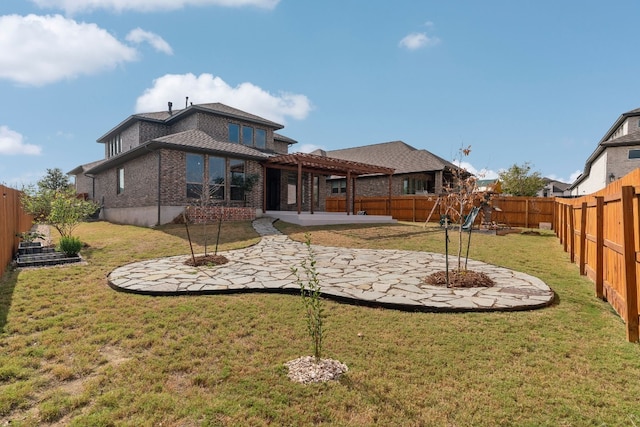 rear view of house featuring a yard, a pergola, and a patio area