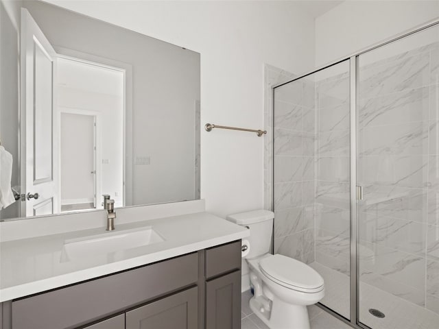 bathroom featuring toilet, vanity, tile patterned floors, and a shower with door