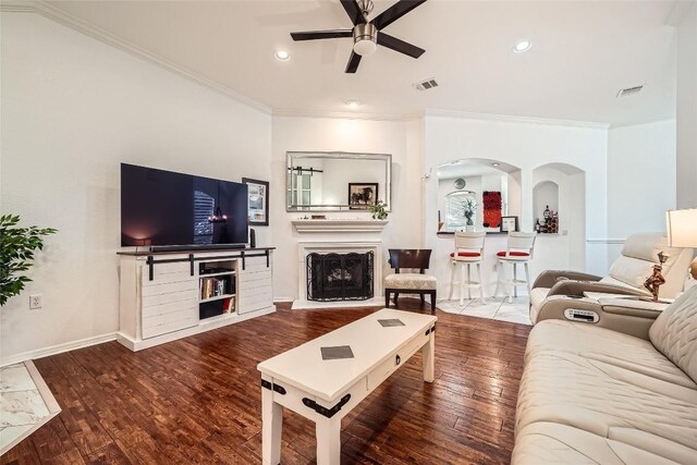 living room featuring hardwood / wood-style floors, ceiling fan, and ornamental molding