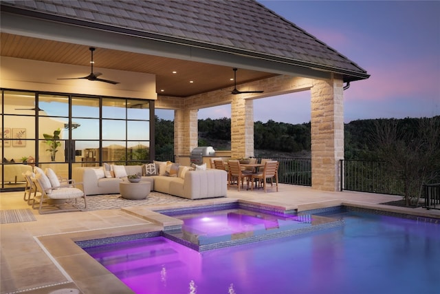 pool at dusk featuring ceiling fan, an outdoor living space, a patio area, an in ground hot tub, and area for grilling