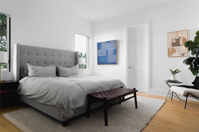 bedroom with multiple windows and hardwood / wood-style floors