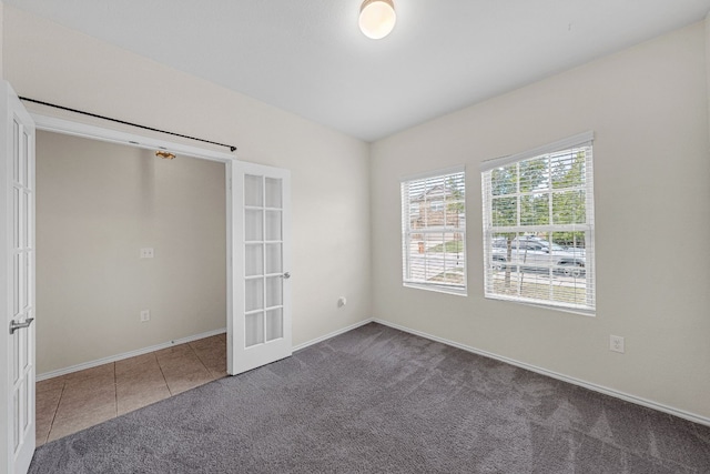 empty room with french doors and dark carpet