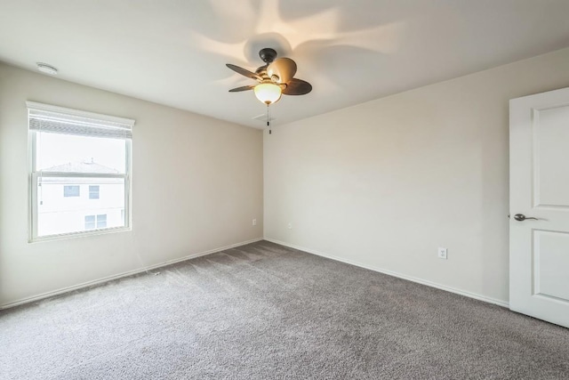 carpeted spare room featuring ceiling fan