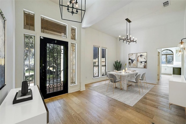 dining space with a high ceiling and light wood-type flooring