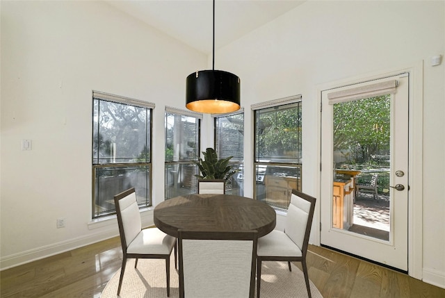 dining space featuring dark hardwood / wood-style floors and high vaulted ceiling