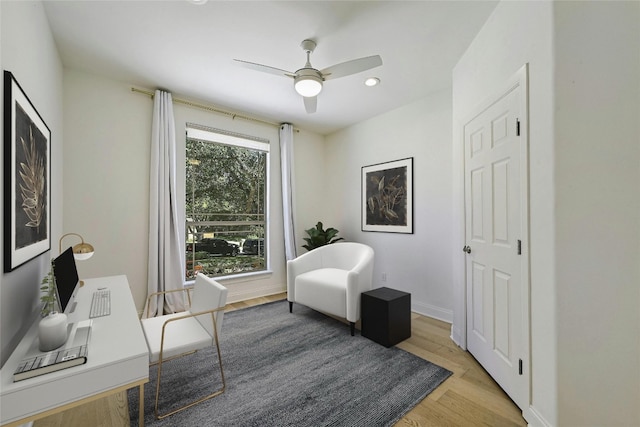 living area with ceiling fan and light hardwood / wood-style floors