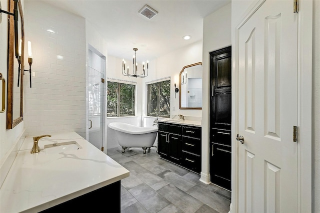 bathroom featuring plus walk in shower, vanity, and an inviting chandelier