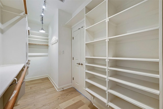 spacious closet with light hardwood / wood-style floors