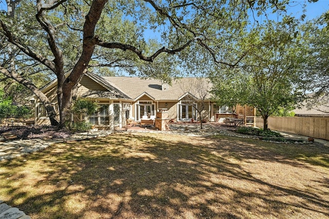 view of front of house featuring a front yard, a patio, and a sunroom