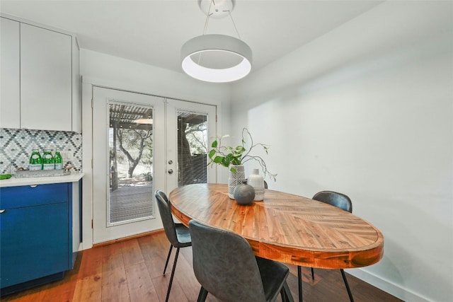 dining space with dark hardwood / wood-style floors and french doors