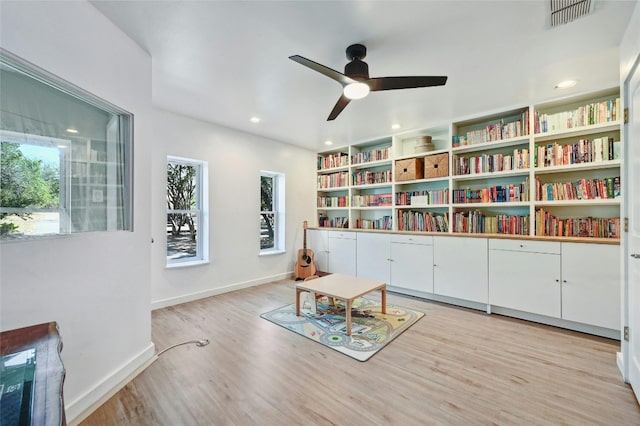 living area featuring ceiling fan and light hardwood / wood-style floors