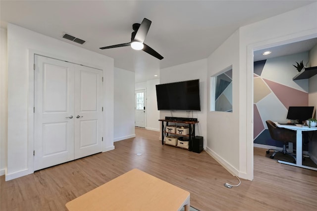 living room with light hardwood / wood-style floors and ceiling fan