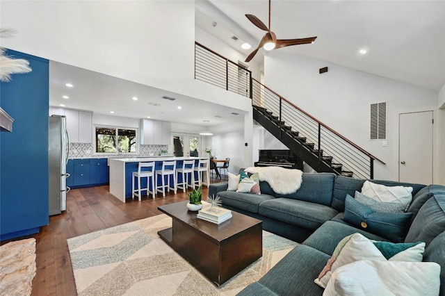 living room featuring dark hardwood / wood-style floors, high vaulted ceiling, and ceiling fan