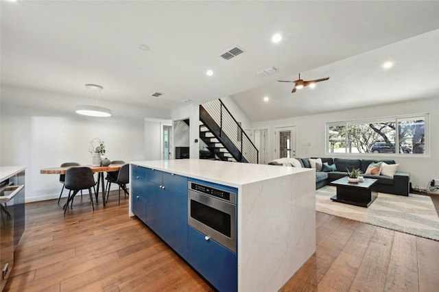 13016 S Madrone Trl, Austin, TX 78737 - kitchen featuring blue cabinets, a center island, light wood-style flooring, appliances with stainless steel finishes, and recessed lighting