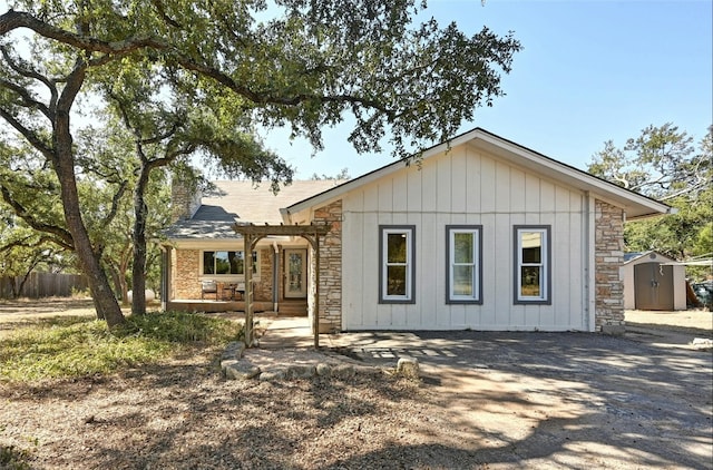 view of front of home with a storage unit and a pergola