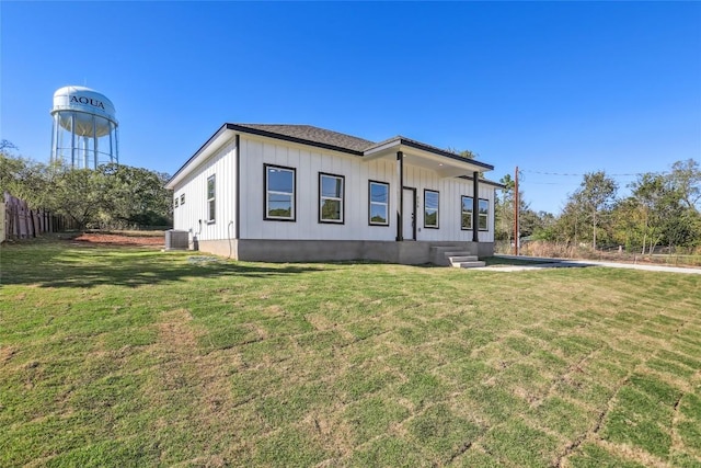 view of front of home featuring a front yard and central AC