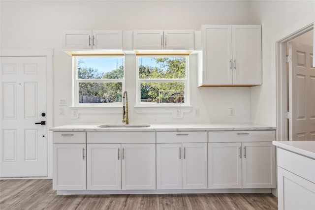 kitchen featuring sink, white cabinets, and light hardwood / wood-style flooring