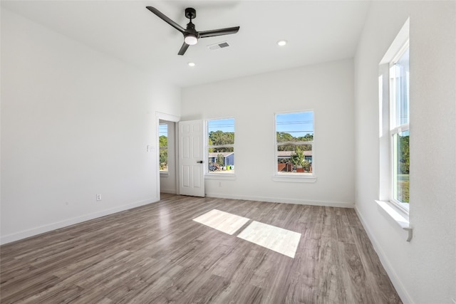 unfurnished room with ceiling fan, a healthy amount of sunlight, and wood-type flooring