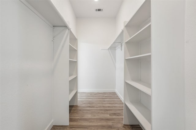 walk in closet with wood-type flooring