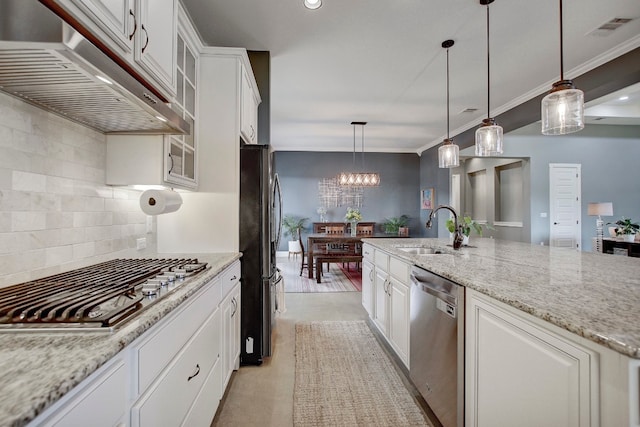 kitchen featuring appliances with stainless steel finishes, light stone counters, sink, pendant lighting, and white cabinets