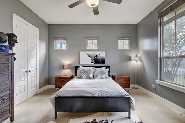 bedroom with ceiling fan, a closet, and multiple windows