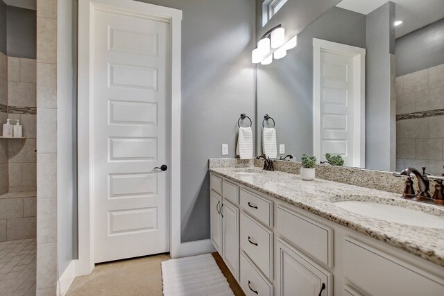 bathroom featuring a tile shower and vanity