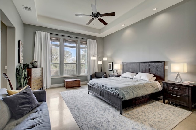 bedroom with a raised ceiling and ceiling fan