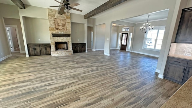 unfurnished living room with a fireplace, hardwood / wood-style floors, crown molding, and beam ceiling