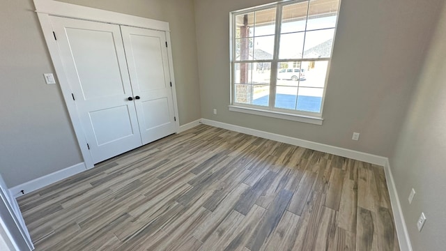 unfurnished bedroom with a closet and light hardwood / wood-style flooring