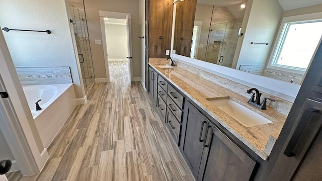 bathroom with plus walk in shower, vanity, and wood-type flooring