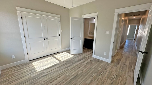 unfurnished bedroom featuring light hardwood / wood-style floors and a closet