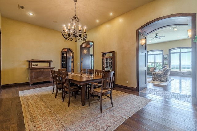 dining area with ceiling fan with notable chandelier and dark wood-type flooring