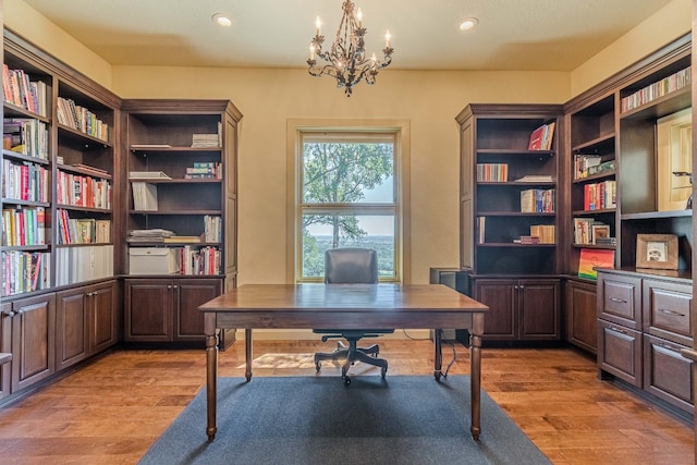 office space with light hardwood / wood-style floors and a notable chandelier