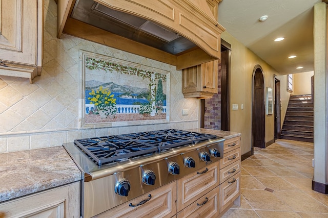 kitchen featuring backsplash, light brown cabinetry, custom range hood, and stainless steel gas stovetop