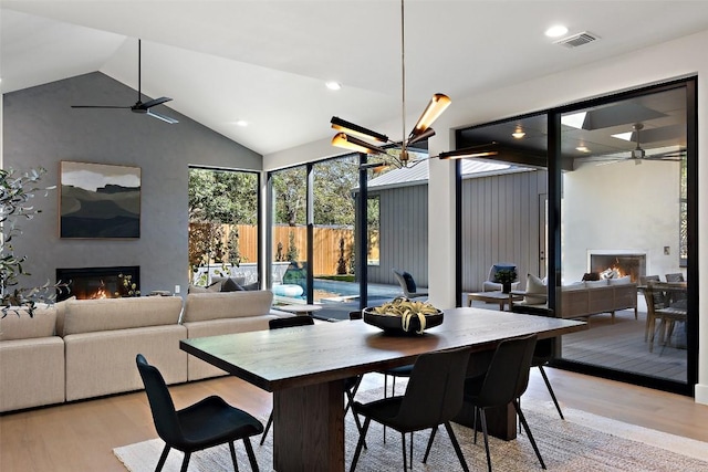 2606 Cavileer Ave, Austin, TX 78757 - dining room featuring a glass covered fireplace, a ceiling fan, light wood finished floors, high vaulted ceiling, and recessed lighting
