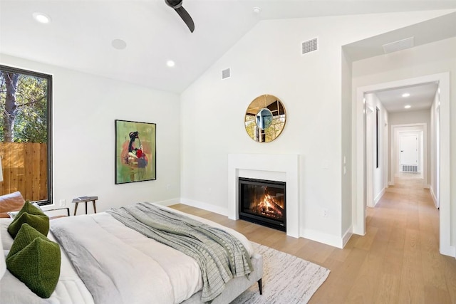 2606 Cavileer Ave, Austin, TX 78757 - bedroom featuring light wood-style floors, a glass covered fireplace, high vaulted ceiling, baseboards, and recessed lighting