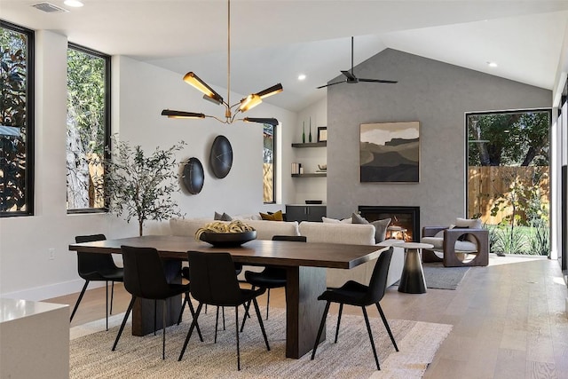 2606 Cavileer Ave, Austin, TX 78757 - dining space featuring wood finished floors, a glass covered fireplace, recessed lighting, baseboards, and high vaulted ceiling