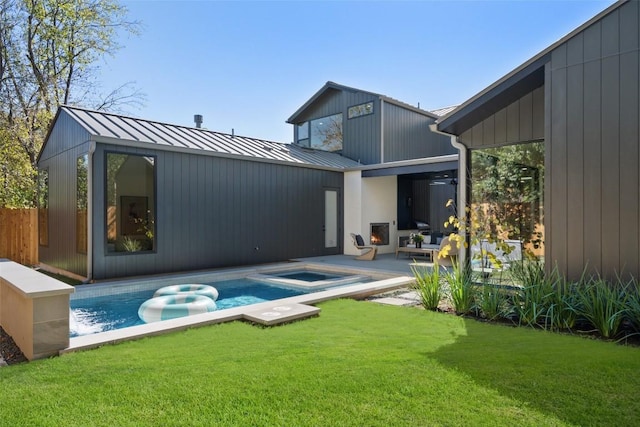 2606 Cavileer Ave, Austin, TX 78757 - rear view of house with an in-ground hot tub, an outdoor pool, a standing seam roof, a yard, and a metal roof