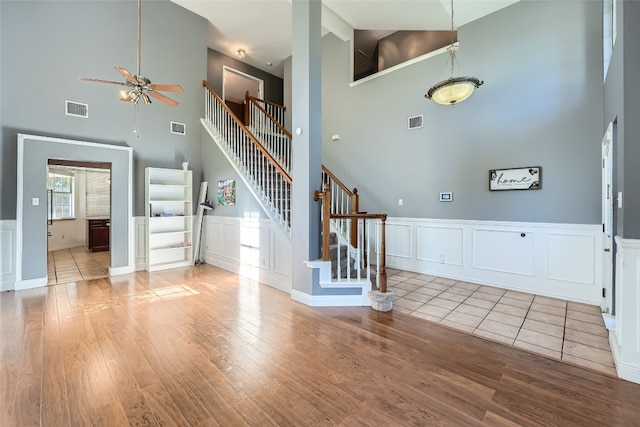 entryway featuring ceiling fan, high vaulted ceiling, and light tile patterned floors