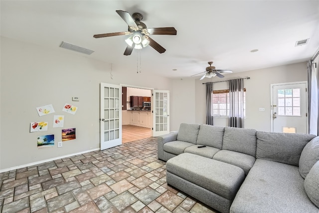 living room featuring ceiling fan and french doors