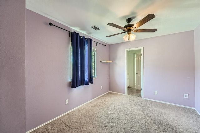 spare room featuring light carpet and ceiling fan