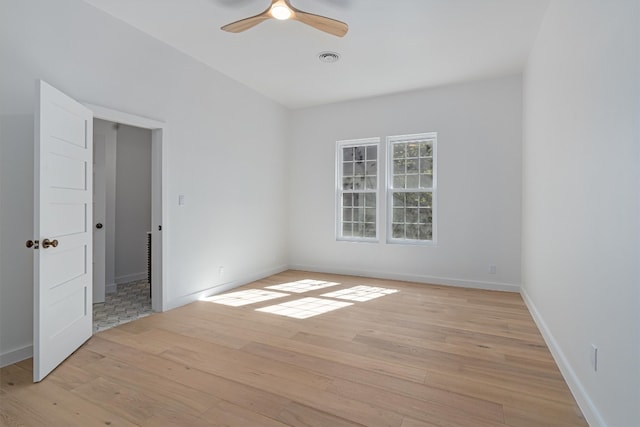 empty room with ceiling fan and light hardwood / wood-style floors