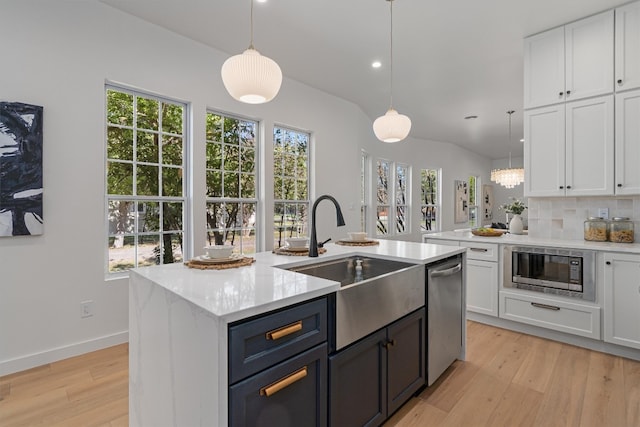 kitchen with stainless steel appliances, white cabinetry, sink, and pendant lighting