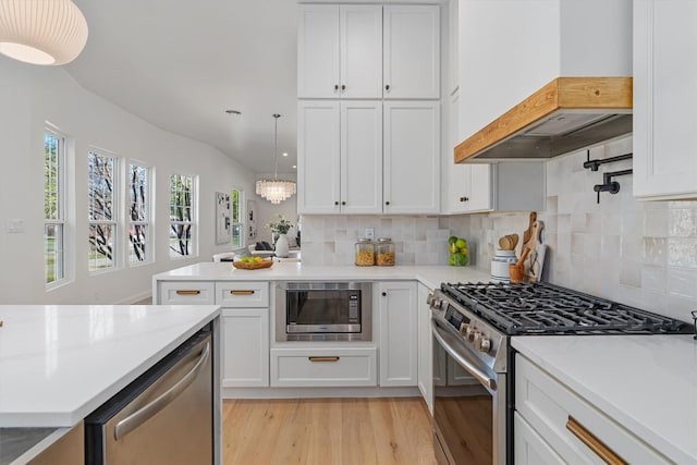 1207 Lexington St, Taylor, TX 76574 - kitchen with appliances with stainless steel finishes, custom range hood, light wood-style floors, white cabinetry, and recessed lighting